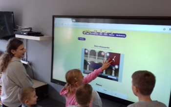 Powiększ obraz: uczniowie korzystają z tablicy interaktywnej na świetlicy szkolnej